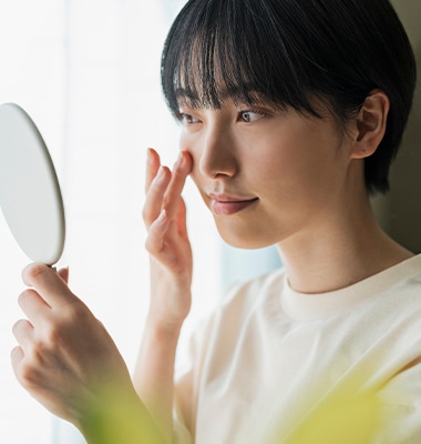 手鏡で肌の状態を確認する女性